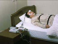 病院のベッドで脳波や筋電図などのセンサーを装着し、PSG検査（終夜睡眠ポリグラフ検査）を受けている男性